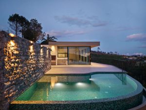 A moradia ao entardecer, com a piscina integrada no espaço exterior.